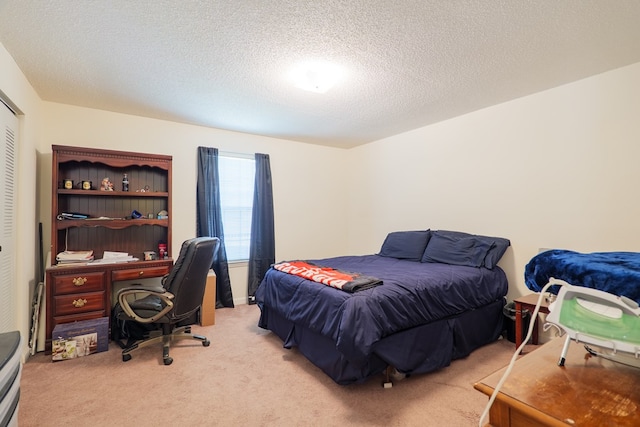 bedroom featuring a textured ceiling, light colored carpet, and a closet