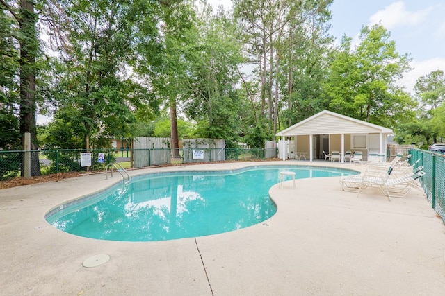 pool with fence and a patio
