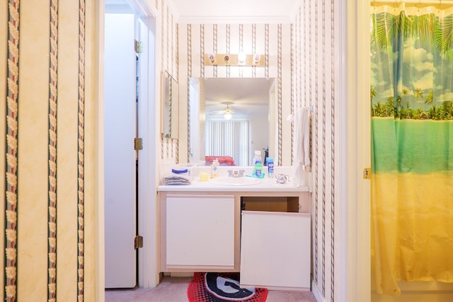 bathroom with crown molding, a ceiling fan, wallpapered walls, and vanity