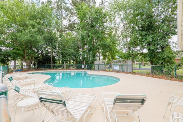 pool featuring fence and a patio area