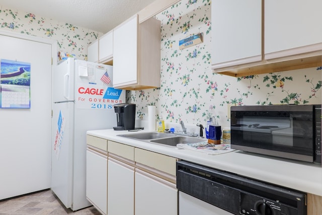 kitchen with black microwave, wallpapered walls, light countertops, a sink, and dishwasher