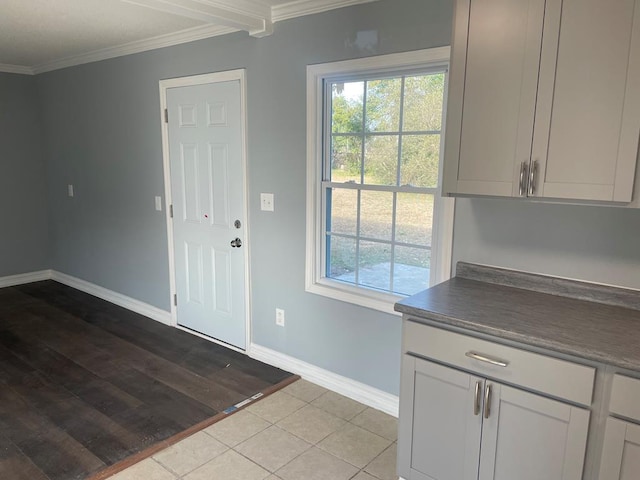 foyer entrance featuring crown molding, plenty of natural light, and light hardwood / wood-style floors