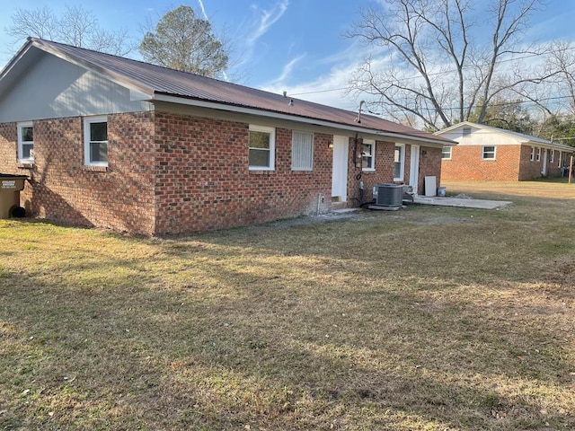 back of house featuring a lawn and central air condition unit