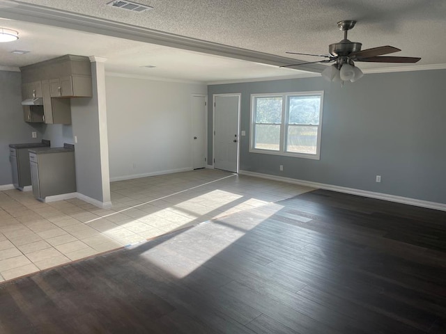 unfurnished living room featuring ceiling fan, ornamental molding, light hardwood / wood-style floors, and a textured ceiling