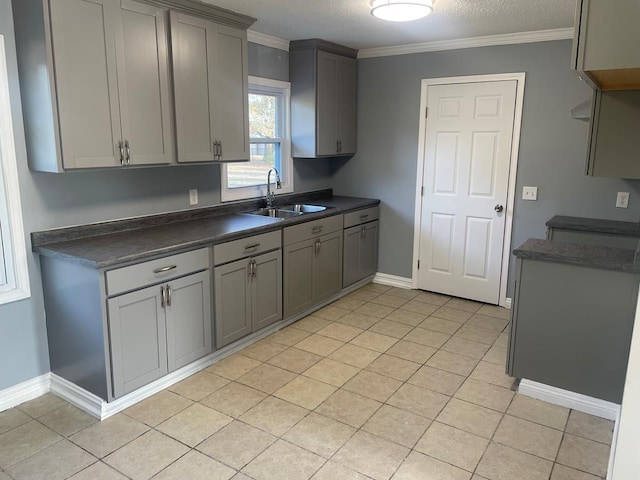 kitchen featuring sink, crown molding, gray cabinets, and light tile patterned flooring