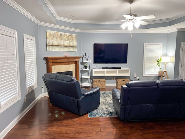 living room featuring hardwood / wood-style flooring, crown molding, baseboards, and ceiling fan