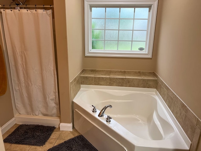 bathroom with a garden tub, a shower stall, and tile patterned flooring