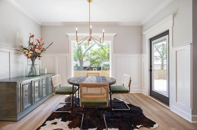 5039 Hatfield Cir, Hahira, GA 31632 - dining room with a decorative wall, a chandelier, light wood-style flooring, crown molding, and a wainscoted wall