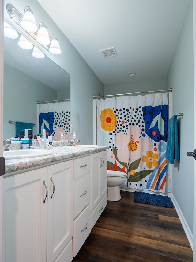 bathroom featuring vanity, hardwood / wood-style flooring, a shower with curtain, and toilet