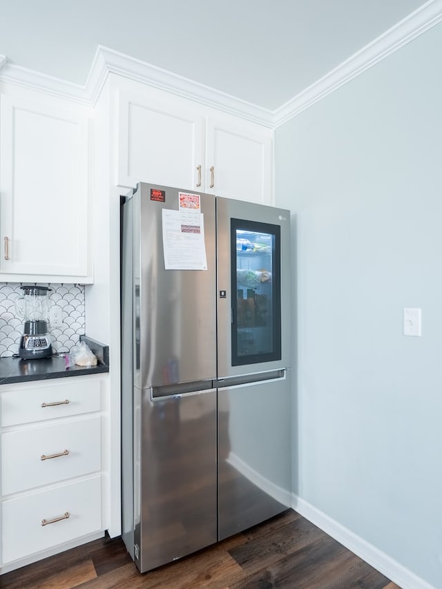 kitchen featuring dark hardwood / wood-style floors, stainless steel fridge, and white cabinets