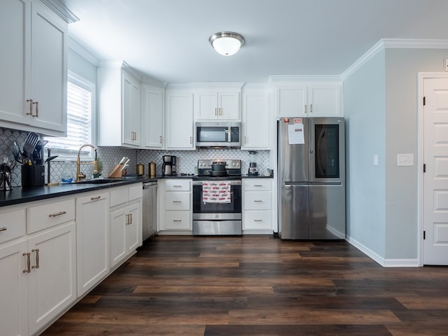 kitchen featuring appliances with stainless steel finishes, sink, dark wood-type flooring, and white cabinets