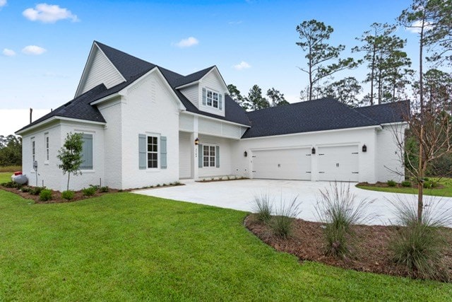 view of front of property with a garage and a front lawn