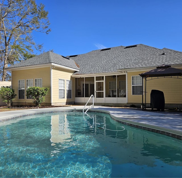 view of swimming pool with a gazebo and a sunroom