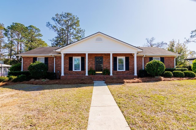 view of front facade with brick siding, a porch, and a front lawn