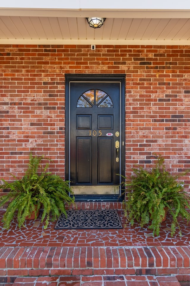 entrance to property featuring brick siding