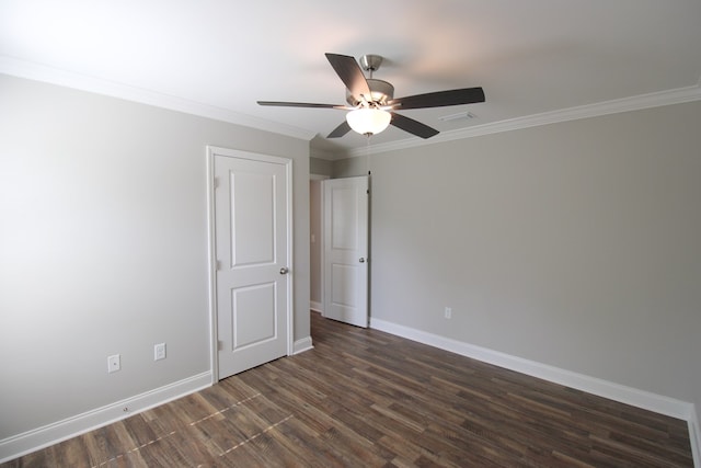 empty room with dark wood finished floors, baseboards, a ceiling fan, and crown molding