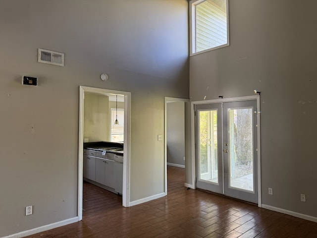 11 Crestwood Cir, Valdosta, GA 31602 - empty room featuring a towering ceiling, baseboards, dark wood-style floors, and french doors