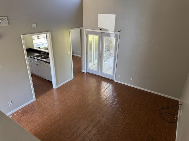 11 Crestwood Cir, Valdosta, GA 31602 - empty room with baseboards, french doors, dark wood-style flooring, and a towering ceiling