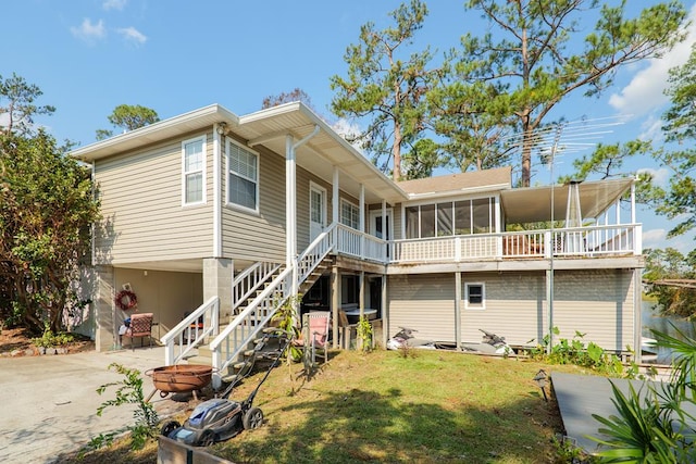 back of house with a yard and a sunroom