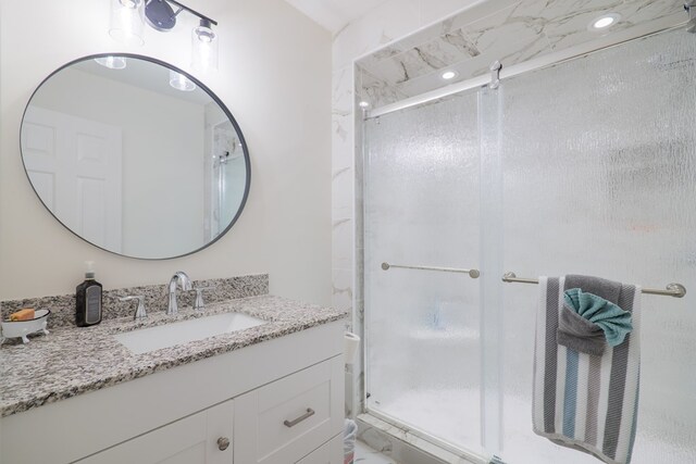 bathroom featuring vanity and a shower with door