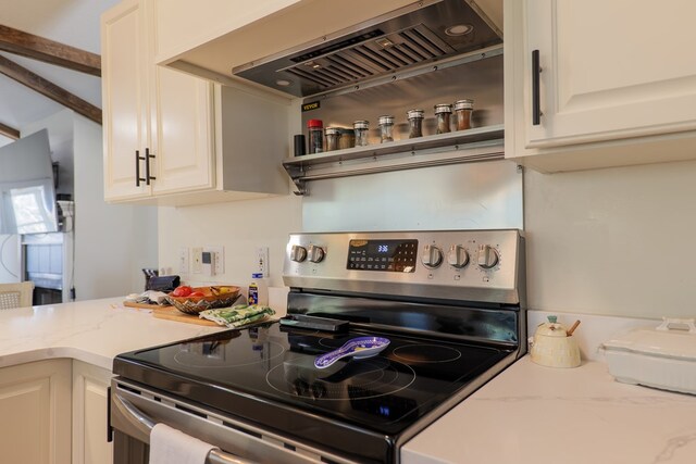 kitchen with light stone countertops, wall chimney exhaust hood, and stainless steel electric range