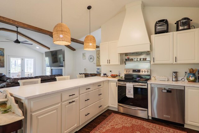 kitchen with custom exhaust hood, stainless steel appliances, pendant lighting, white cabinets, and lofted ceiling