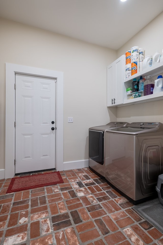 laundry area featuring separate washer and dryer and cabinets