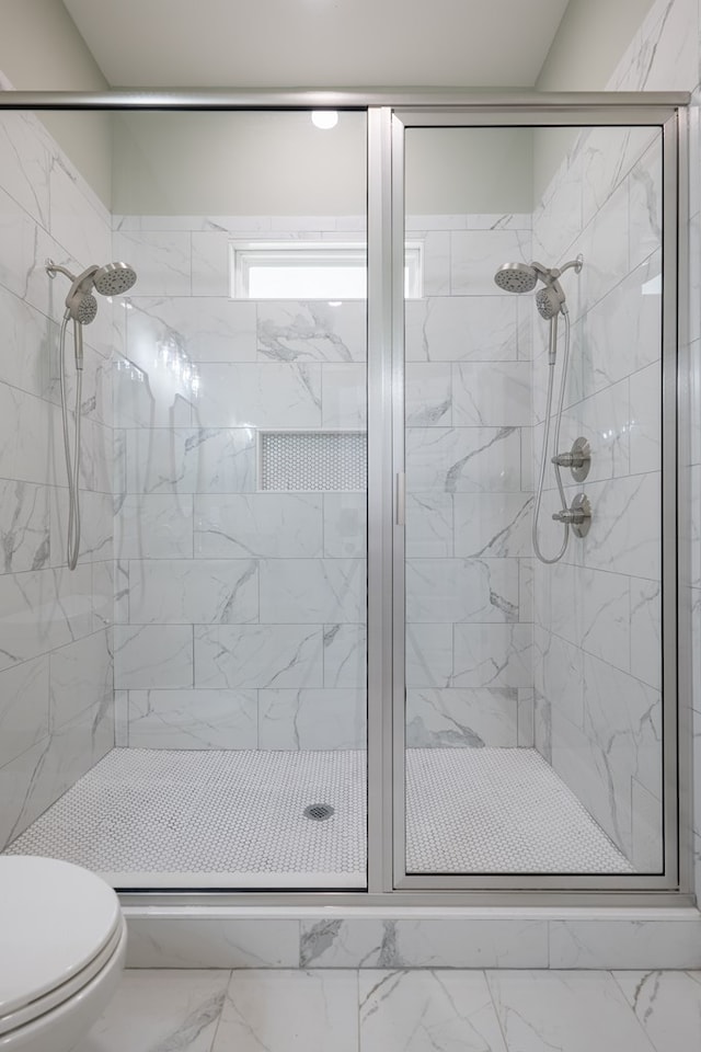 bathroom featuring an enclosed shower and toilet