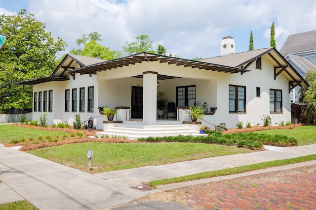 back of property featuring a lawn and covered porch