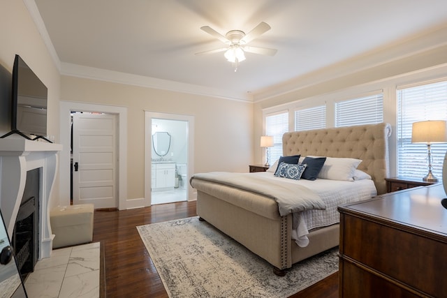 bedroom with connected bathroom, multiple windows, ceiling fan, and dark hardwood / wood-style flooring