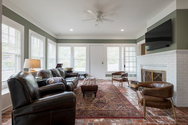 living room with ceiling fan, a fireplace, and ornamental molding