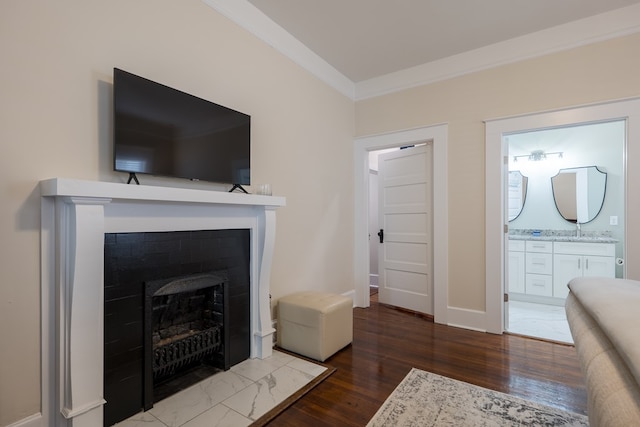 living room featuring sink, wood-type flooring, and ornamental molding