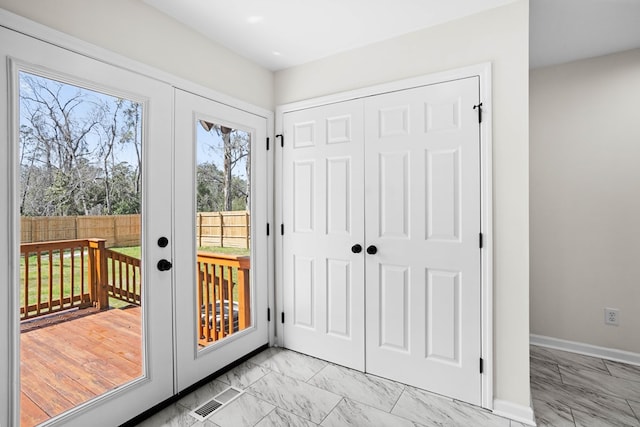 doorway featuring marble finish floor, french doors, and baseboards