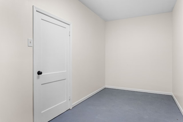 unfurnished room with concrete floors and baseboards