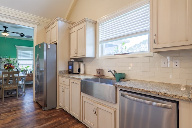 kitchen featuring stainless steel appliances, plenty of natural light, sink, and light stone counters