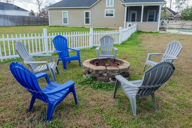 view of yard with a sunroom, a swimming pool, and a fire pit