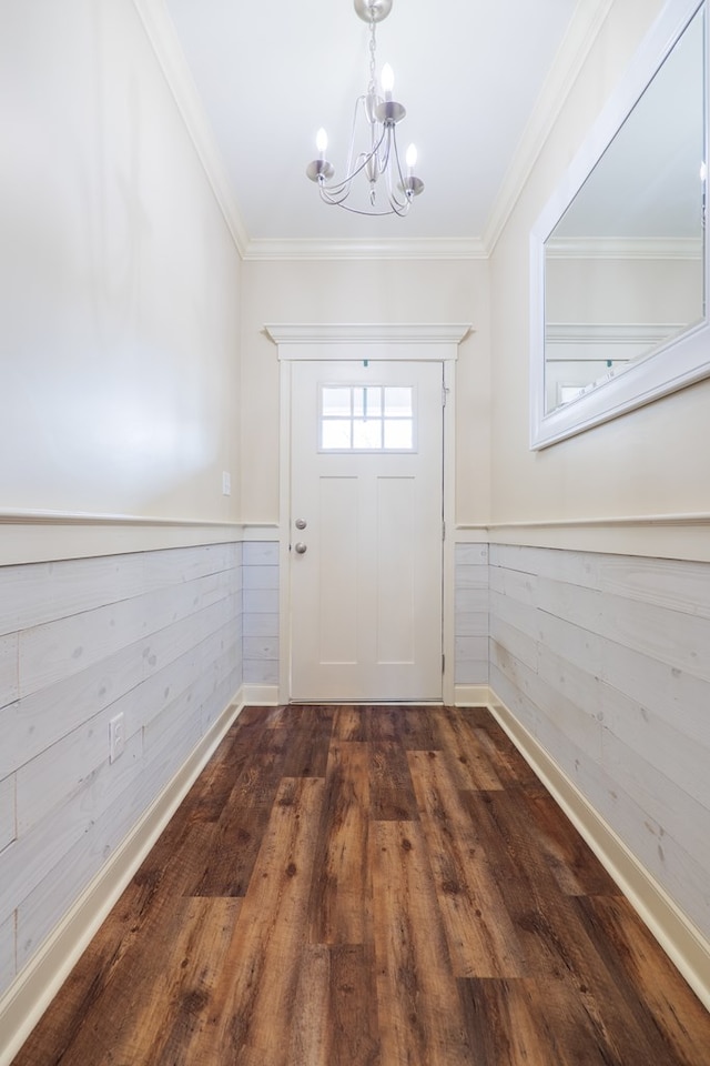 doorway to outside with a notable chandelier, crown molding, dark wood-type flooring, and wooden walls