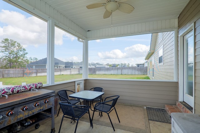 sunroom with a water view and ceiling fan