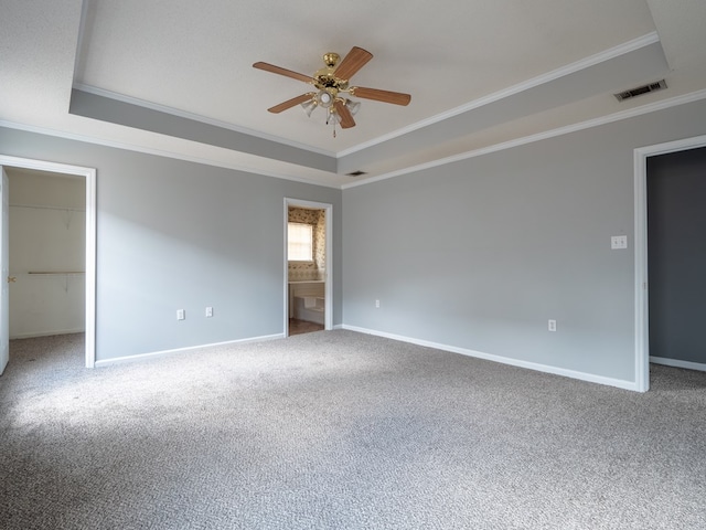 unfurnished room with crown molding, carpet flooring, and a tray ceiling