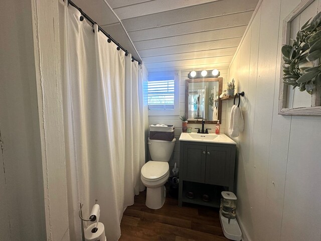 bathroom featuring hardwood / wood-style floors, wooden walls, vanity, toilet, and wooden ceiling