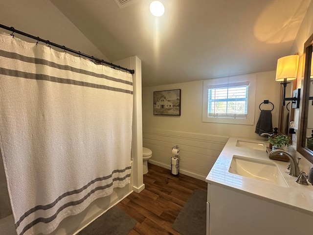 full bathroom with lofted ceiling, hardwood / wood-style flooring, shower / tub combo, vanity, and toilet