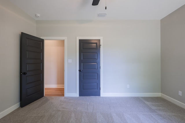 empty room featuring carpet floors and ceiling fan