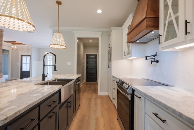 kitchen featuring pendant lighting, sink, stainless steel appliances, white cabinets, and custom exhaust hood