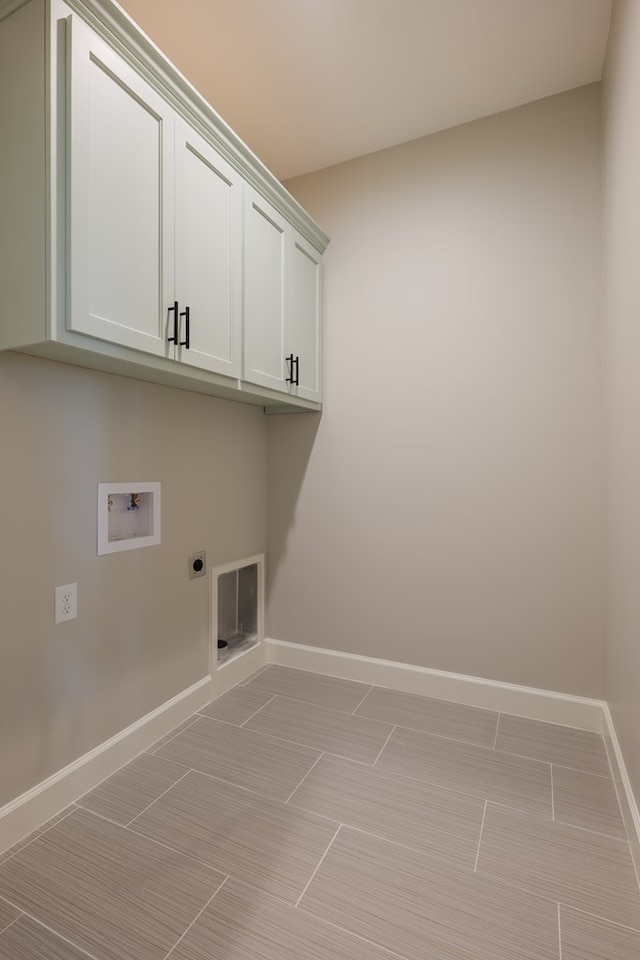 laundry room featuring electric dryer hookup, washer hookup, and cabinets