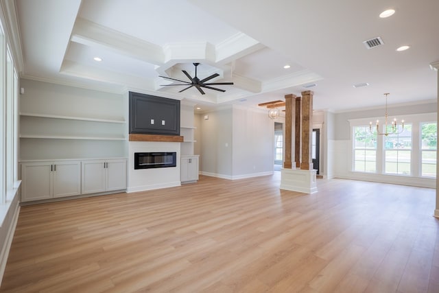 unfurnished living room with ceiling fan with notable chandelier, a fireplace, ornamental molding, and light wood-type flooring