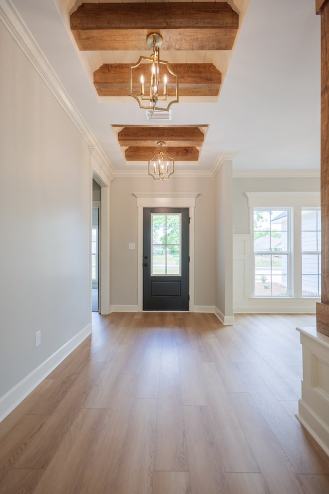 entryway featuring hardwood / wood-style flooring, ornamental molding, a notable chandelier, and beamed ceiling