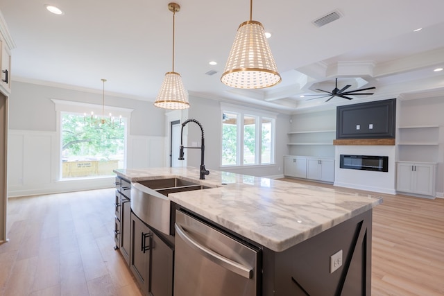 kitchen with sink, crown molding, light stone counters, dishwasher, and an island with sink