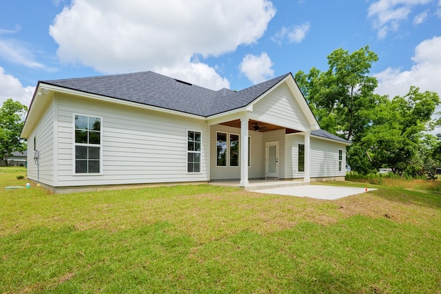 rear view of property featuring ceiling fan, a yard, and a patio area