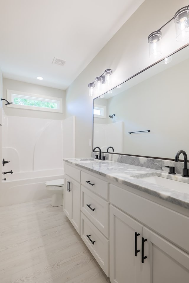 full bathroom featuring vanity, wood-type flooring,  shower combination, and toilet