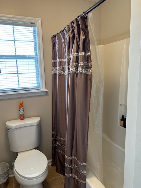 bathroom featuring toilet, tile patterned flooring, and baseboards